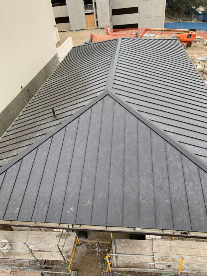 Commercial metal roof construction with crane equipment in Moosic